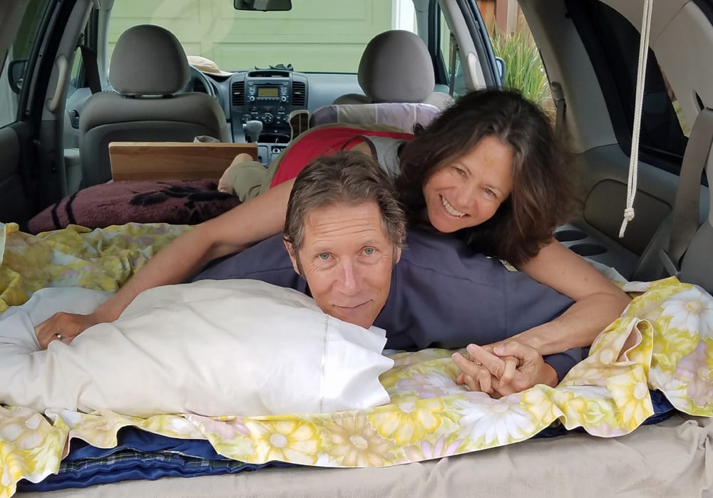 Camp for Free author and former Mount Shasta resident John Soares on the platform bed in his minivan with his sweetheart Stephanie Hoffman